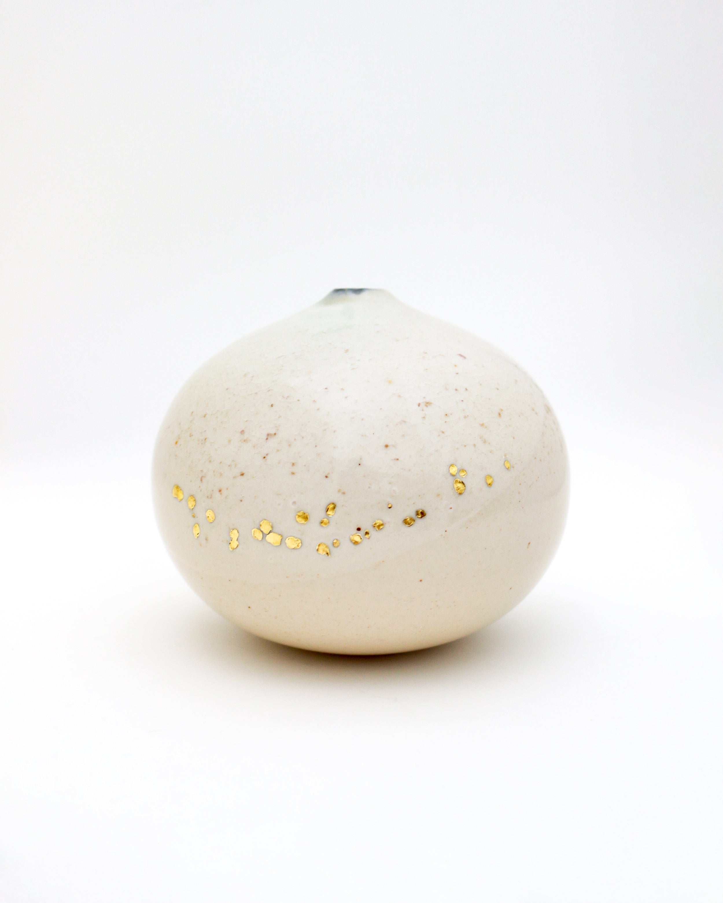 Wood-fired spherical vase with golden pinholes