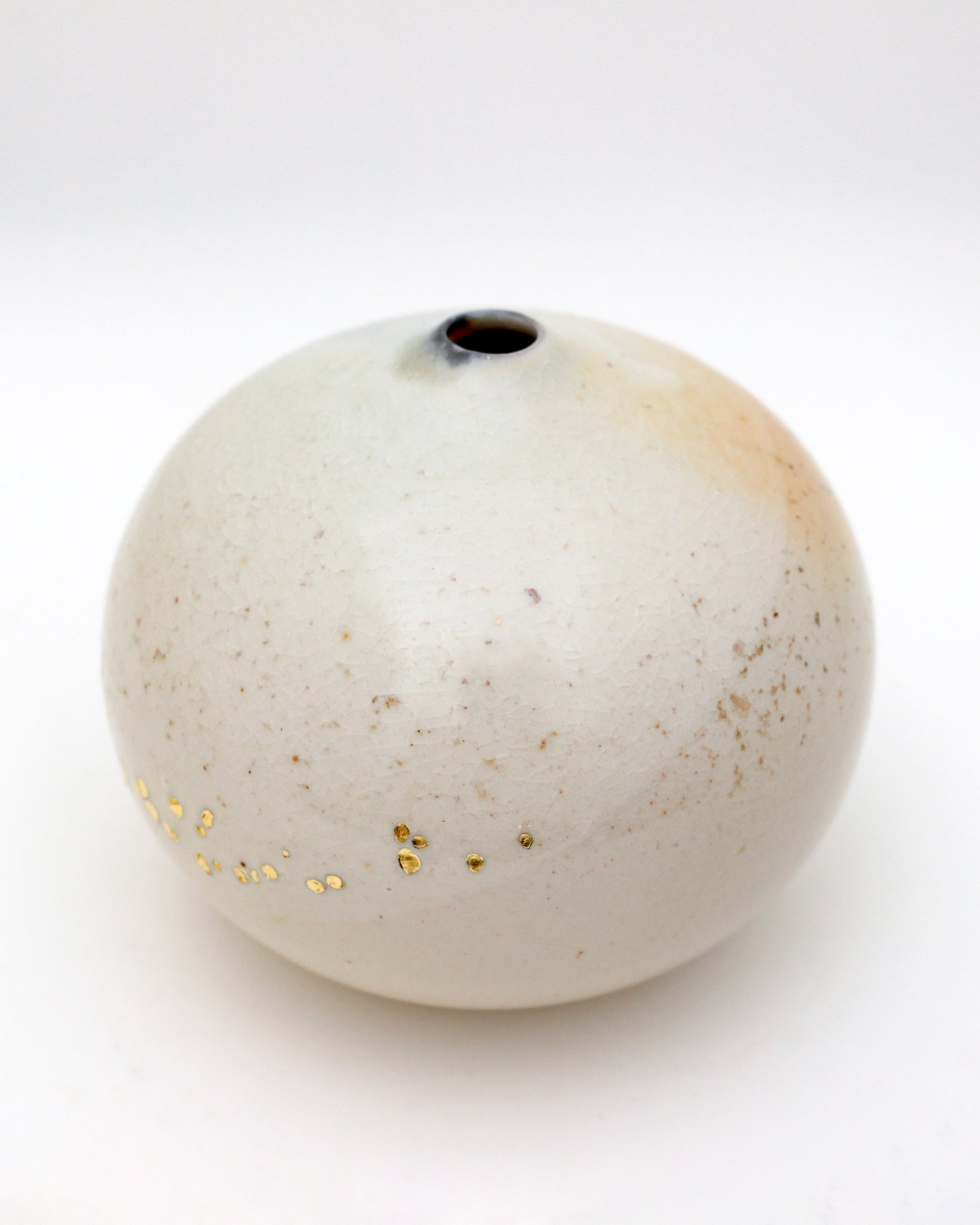 Wood-fired spherical vase with golden pinholes